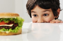 Niño mirando una hamburguesa